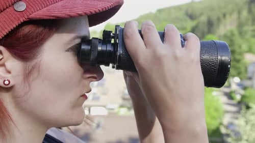 Young Woman with Binoculars Observes the Outdoors