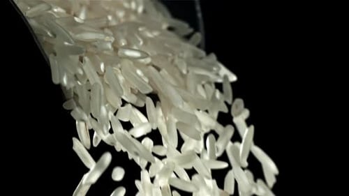 Pouring Rice Grains on Black Background