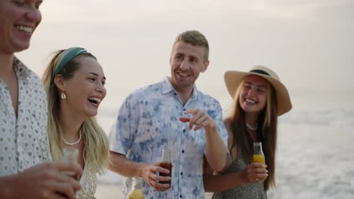 Groupe d'amis, hommes et femmes, avec des bouteilles de kombucha, boisson Walk By Ocean Waves, chat and laugh on