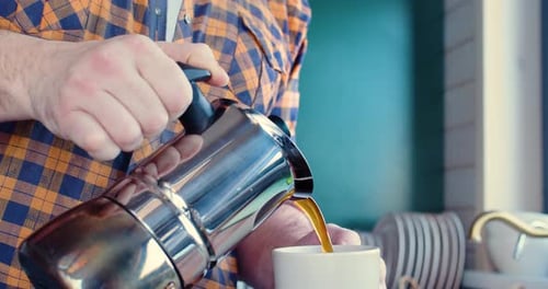 Man Pours Fresh Coffee from Stovetop Espresso Maker