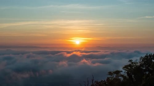 Time lapse video of dramatic sunrise with fog on a cloudy morning.