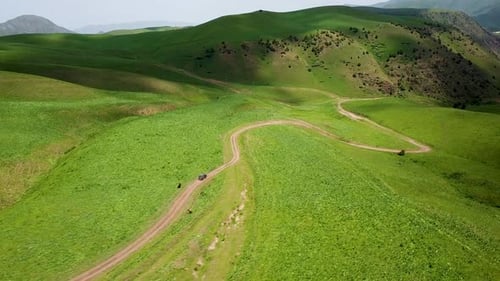 Drone: flies behind a car through a gorge in the mountains of Kyrgyzstan