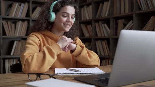 Woman on video call with headphones at home