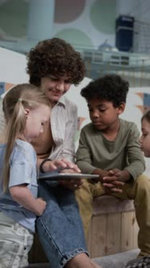 Woman Reading Tablet With Children Indoors