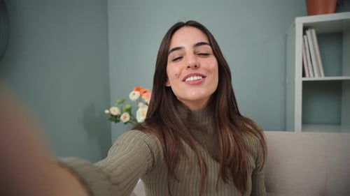 Woman Smiling and Waving at Camera at Home
