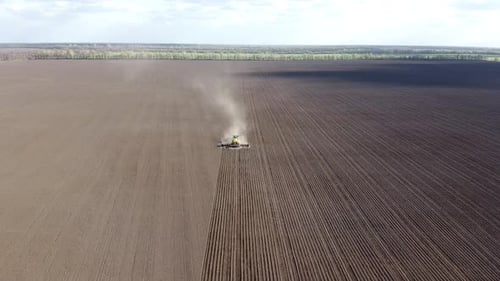 Tractor with yellow seeder working on the field in Ukraine OA Lexa