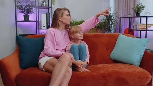 Woman and Child Talk on Couch Indoors