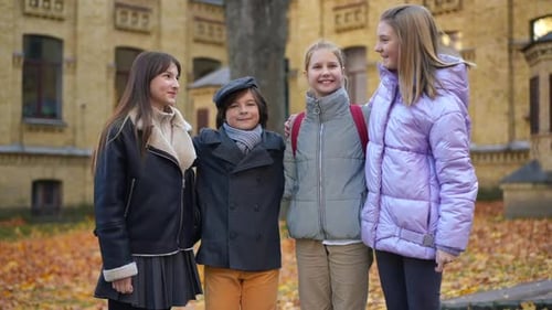 Four Smiling Students Waving, Giving Thumbs Up