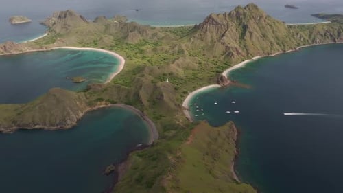 Aerial view of Padar Island coastline with mountain and boats, Indonesia.