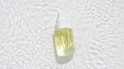 Cosmetic Serum Bottle on a Watery White Background