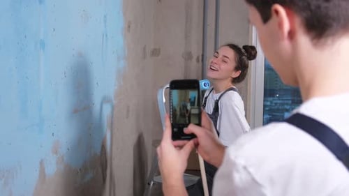 Couple in New Home Man Taking Photo Woman During Repair Works Painting Walls Happy Family Bloggers