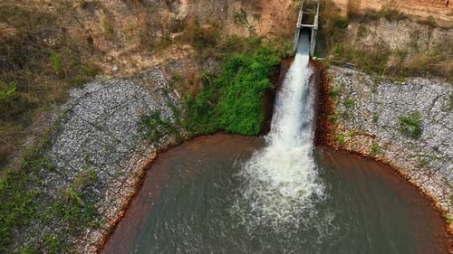 Drone view of irrigation water cascading into a pond.