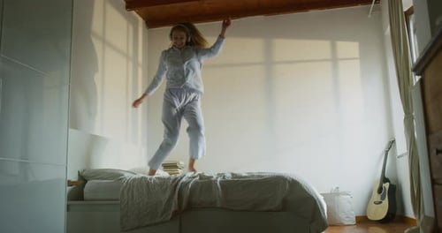 Authentic Shot of an Young Blond Happy Smiling Woman in Pajamas is Having Fun to Dance and Listen