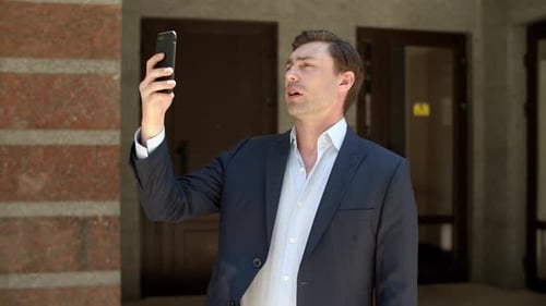 Close Up Serious Businessman Talking to Partner by Face Time Outdoors. Confident