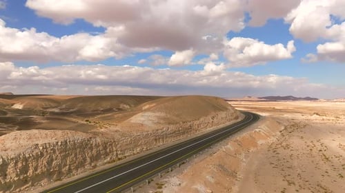 Empty Desert highway mountain road with Blue cloudy sky