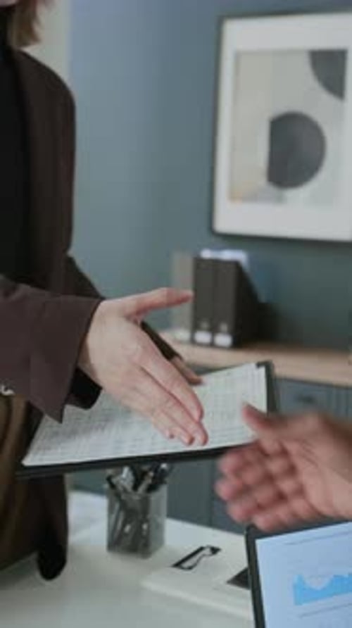 Close-Up of Female Client and Financial Advisor Shaking Hands in Office