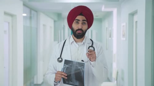 Man with X-Ray Talking in Hospital Hallway