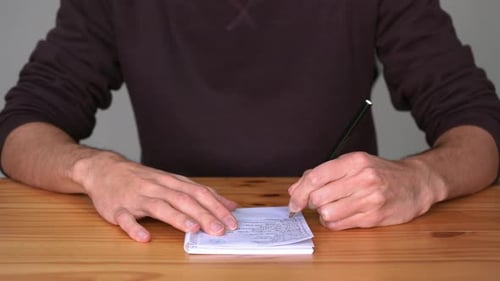 Man Writing On A Notebook With Left Hand. close up