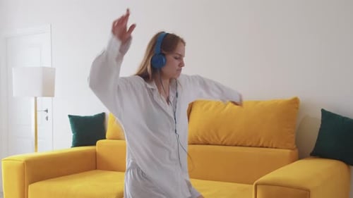 Carefree Woman Dancing at Home with Headphones On
