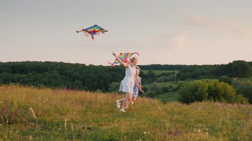 A Woman Plays with Her Daughter Running Around in a Circle with an Air Kite the Girl is Cheerfully