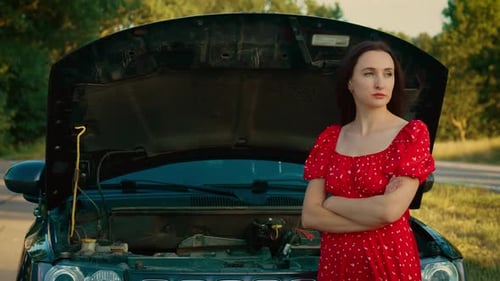Woman Standing with Arms Crossed in Front of Open Hood Waiting for Road Repair with Calm Expression