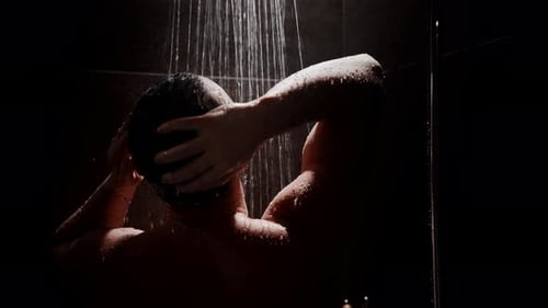 Man Washing Hair in Dark Shower at Night