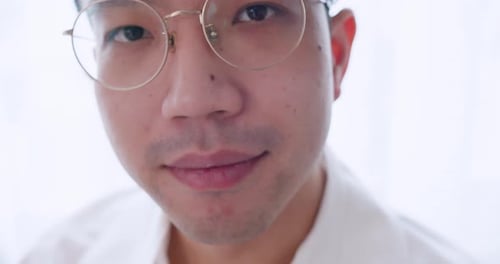 Close up portrait of attractive young hipster man wearing glasses laughing happy looking confident a
