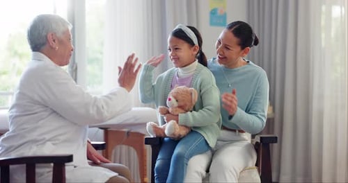 Girl and Mother Visit Caring Pediatrician in Office