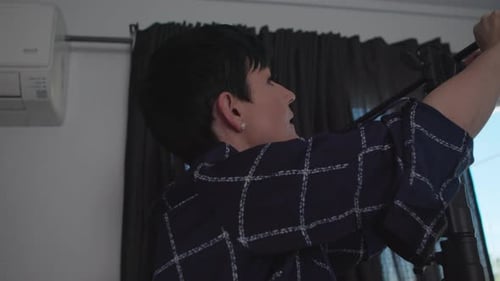 Photographer Adjusts A C-Stand In Her Home Studio. Shot On A Canon C200 In 4k In 2019.