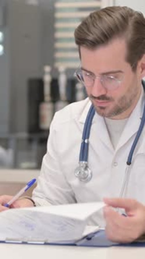 Jeune médecin travaillant sur des documents en clinique