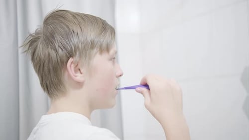 Child Brushing Teeth in Bright Bathroom