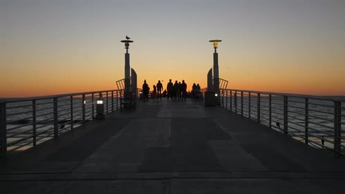 Tracking shot of santa monica pier silhouettes glowing at sunset in California