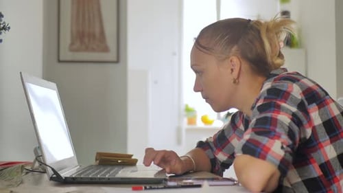 Woman Working on Laptop Computer at Home