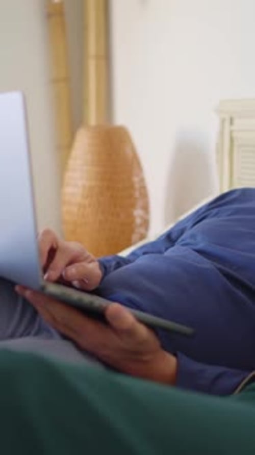 Senior Couple Relaxing in Bed with Laptop Tablet
