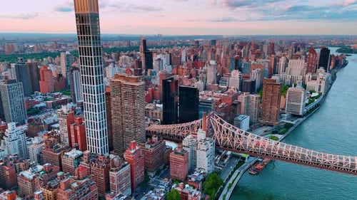 The Queensboro Bridge in New York, USA. Vast scenery of metropolis cityscape at sunset time.