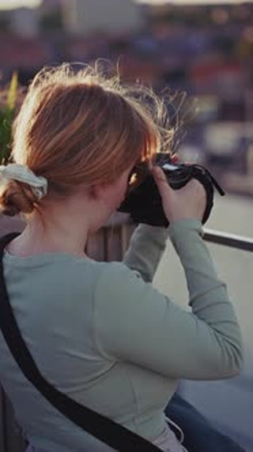 Girl Photographer On Rooftop Capturing City Views At Sunset
