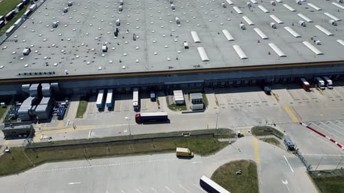 El camión y el remolque atraviesan un gran centro logístico para descargar la carga.