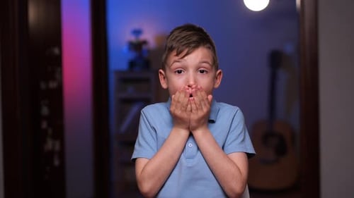 Boy Expresses Shock, Covering Mouth Indoors