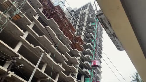 Nuevo edificio en construcción con ascensor rojo que se mueve hacia arriba