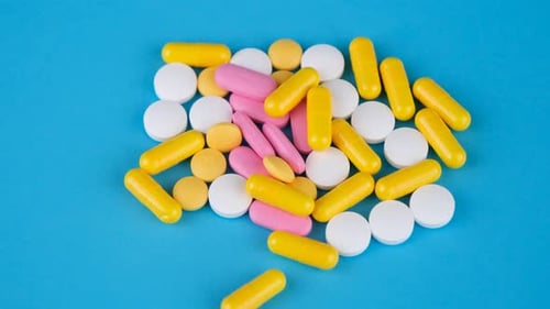 Variety of Pills and Capsules on Blue Surface