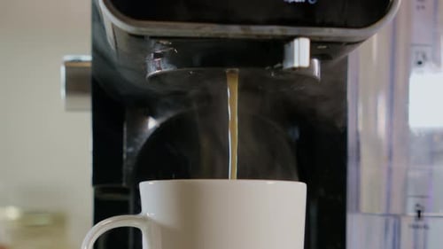 Slow Motion Footage of Black Coffee Pouring From the Machine to White Cup Fresh Cafe in the Kitchen