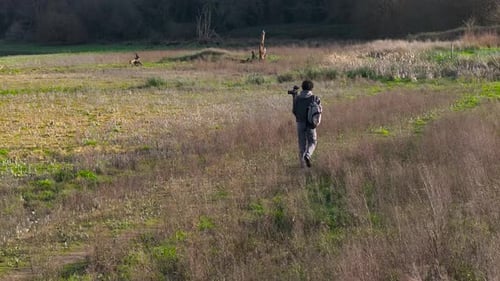 Person with Camera Walks Through Rural Landscape