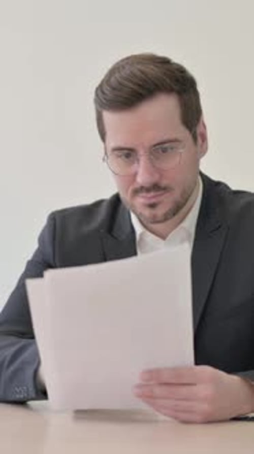 Man in Suit Reads Document and Celebrates Success