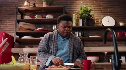 A Young Man Happily Enjoying a Delicious Breakfast in a Bright Modern Kitchen Space