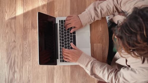 Mann arbeitet von zu Hause aus an seinem Schreibtisch und tippt Laptop, Tastatur, Computer, Ansicht von oben