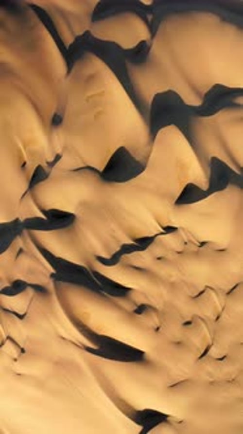 Experience the Vast and Serene Beauty of Sand Dunes in the Desert From an Aerial View