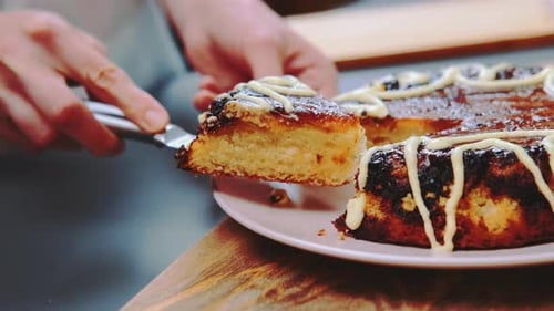 Serving slice of freshly baked frosted cake