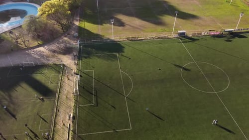 People Practicing Shots On Soccer Goal In Football Green Court, Grass Field