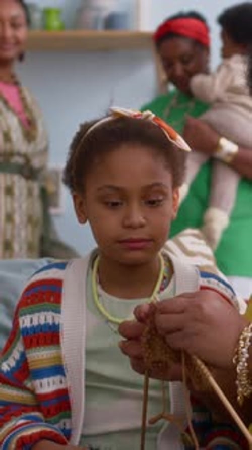 Child Learning to Knit at Home with Family
