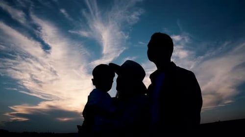 Silhouette of Family Enjoying Dramatic Sky at Sunset